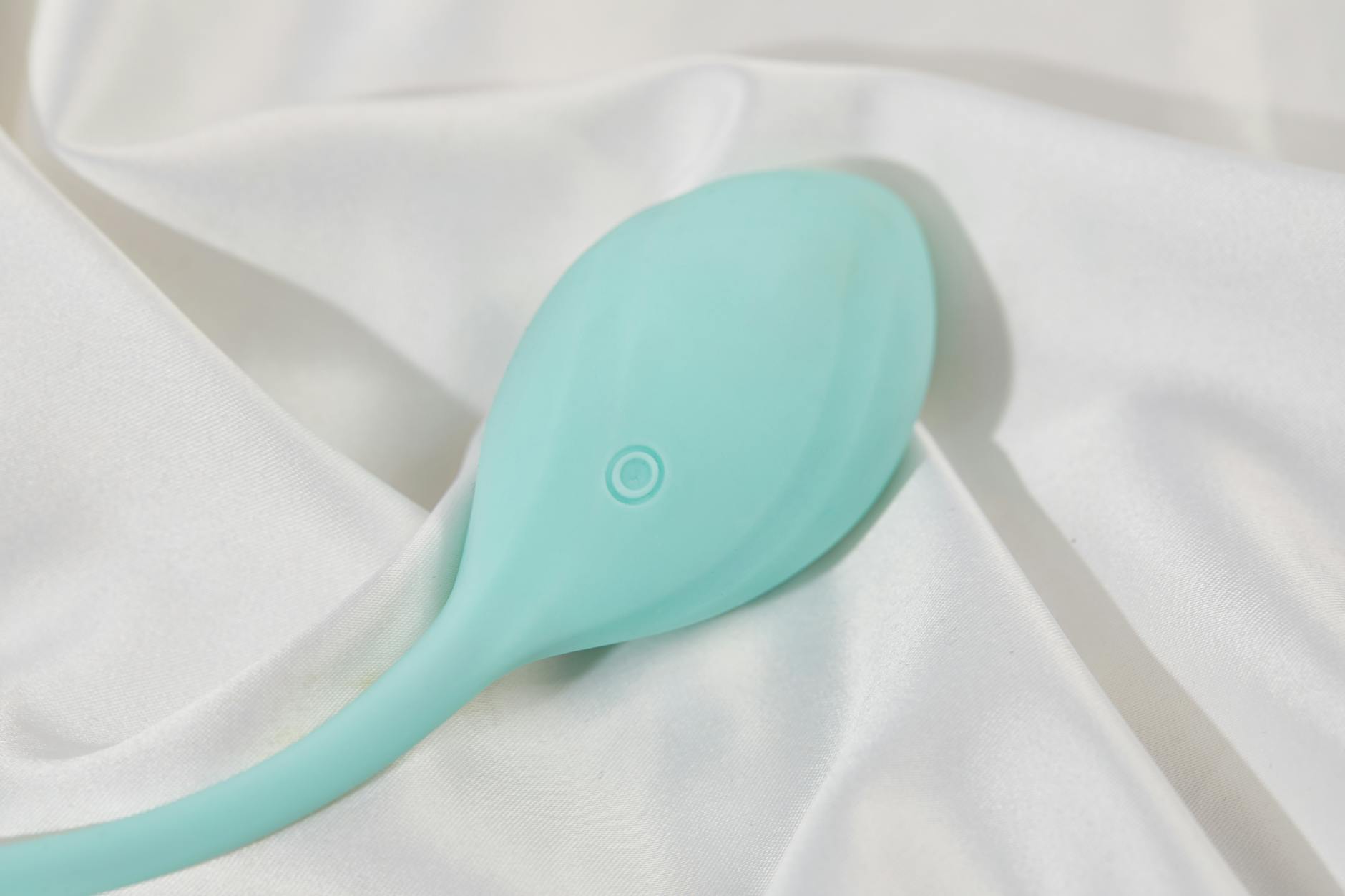 Person holding blue and pink silicone vibrators, considering pleasure tools thoughtfully