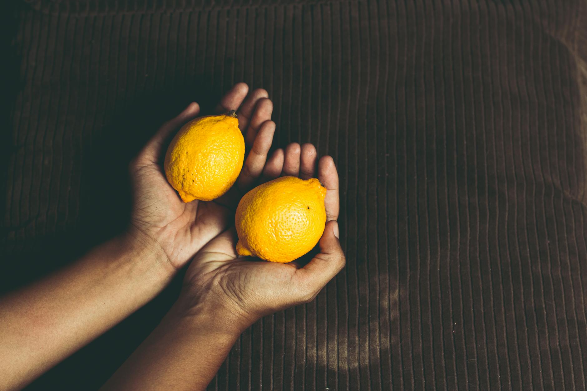 Two fresh lemons held in cupped hands, symbolizing the delicate nature of arousal building
