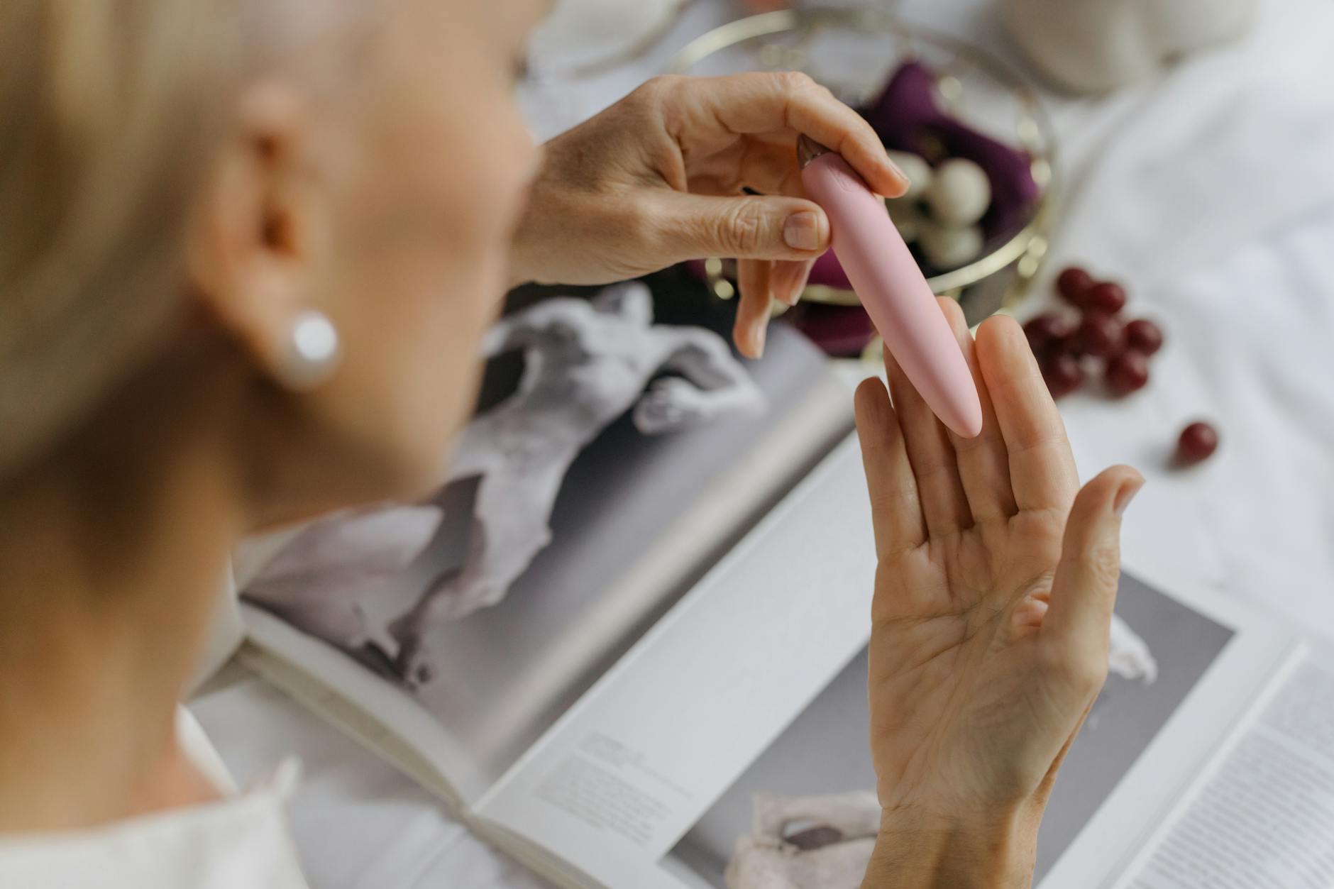 Close-up of hands holding a personal massager, representing intimate pleasure for mature women