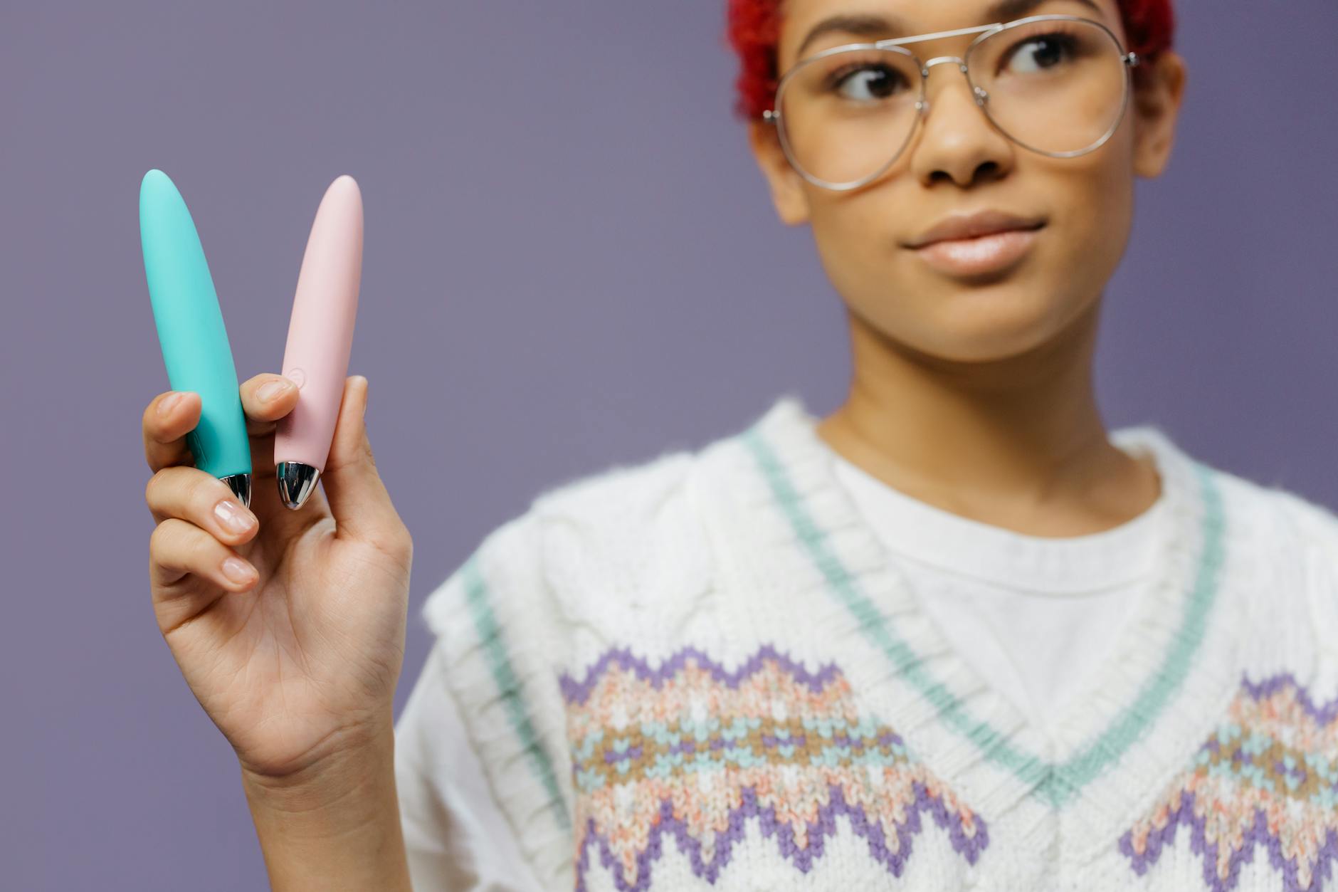 A woman holding colorful vibrators, representing tools for sexual wellness and recovery